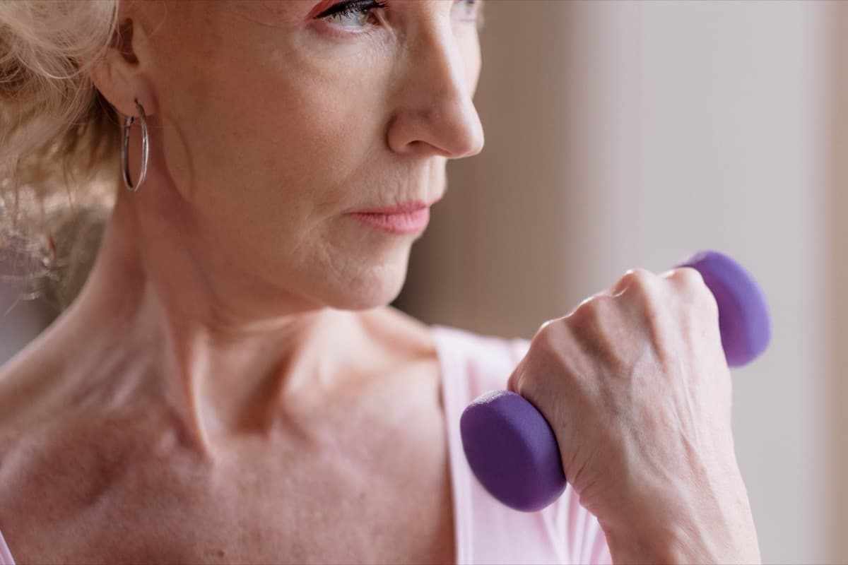 Confident woman over 50 exercising with a dumbbell